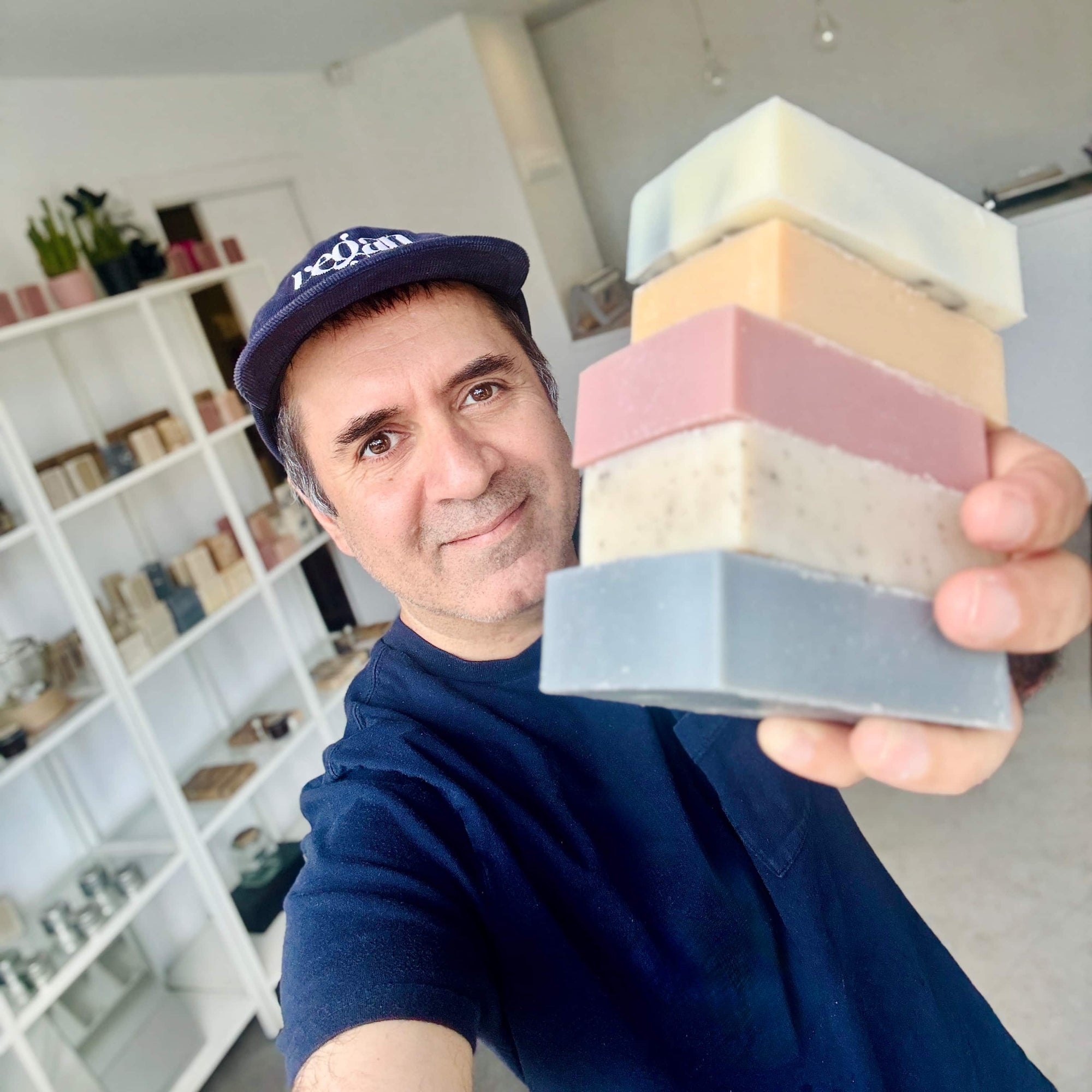 Joulian, SAABOON's founder, holding a stack of handmade soap bars in his Ottawa studio